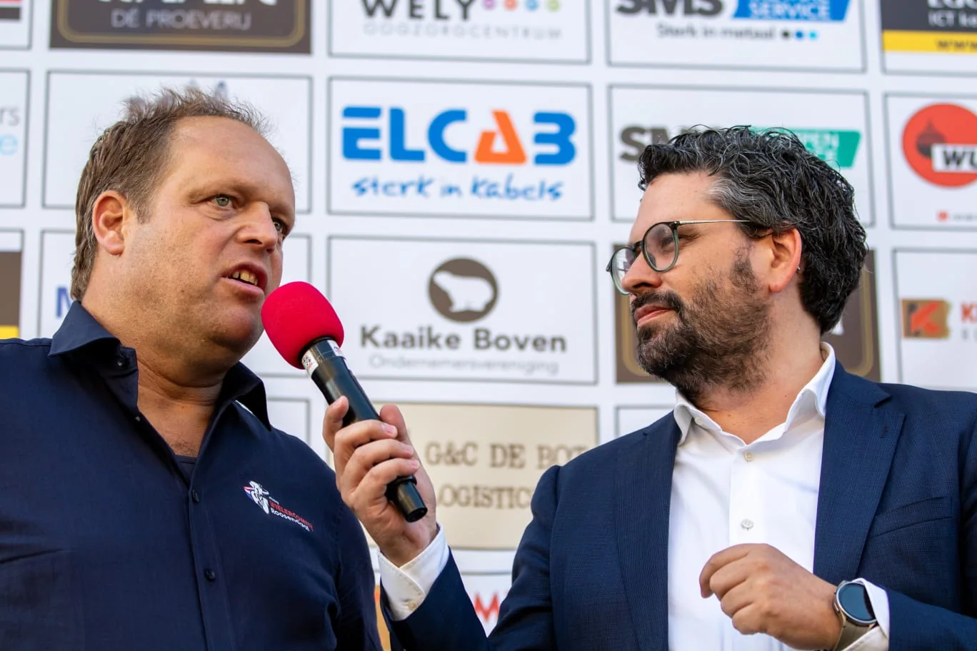 Arwen van Gestel houdt een microfoon bij een spreker tijdens een publieksinterview