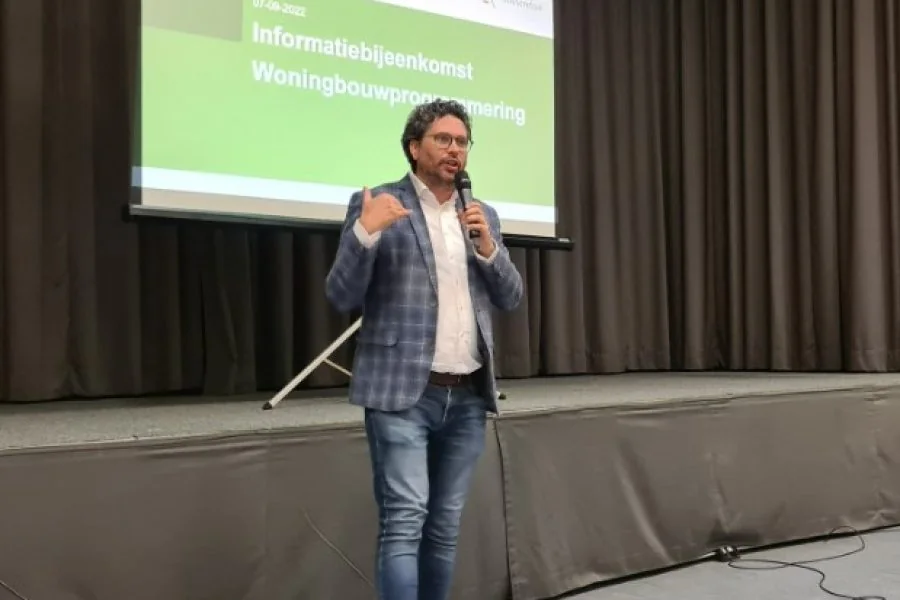Arwen van Gestel presenteert in een zaal met een projectiescherm op de achtergrond